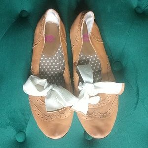 Brown leather flats with white ties